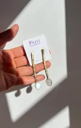 Aros colgantes hechos a mano en bronce, con barra texturada y dije circular de nácar.