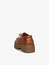 Zapato náutico de cuero color marrón con cordones y plataforma marrón con suela track.