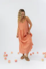 Vestido midi de corte amplio con breteles finos y escote en V. Confeccionado en gasa de algodón con textura, presenta un diseño escalonado con vuelo en el ruedo.