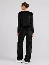 Pantalón de corte recto confeccionado en tejido plush con acabado aterciopelado. Presenta cintura elástica, bolsillos laterales y un bolsillo trasero, ofreciendo una caída fluida y cómoda.