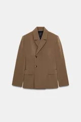 Blazer cruzada color marrón de la colección Zara Woman, con cuello solapa, manga larga, bolsillo de vivo en el pecho y bolsillos con solapa en el delantero. Cierre frontal con botones.