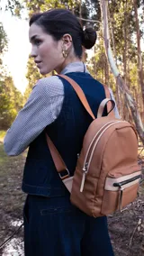 Mochila mediana color rosa, de nylon con detalles en símil cuero en el bolsillo frontal. Tiene asa de mano y correas regulables.