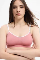 Soutien bralette color rosa con breteles regulables y contorno blanco.