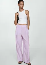 Pantalón wide leg de tiro medio con diseño de rayas verticales finas en color lila. Presenta bolsillos laterales, bolsillos traseros de ribete, trabillas para cinturón y cierre frontal oculto con botón, gancho y cremallera.
