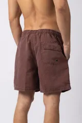 Short de baño de corte relajado en color gris azulado con efecto lavado. Cuenta con cintura elastizada con cordón ajustable, bolsillos laterales y una pequeña etiqueta decorativa en el ruedo.