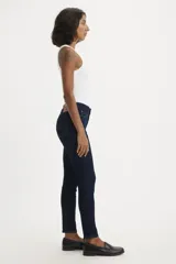Jeans skinny de tiro medio color azul oscuro, ajustados en cadera y muslos, con cierre de bragueta.