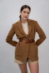 Blazer color camel de baby alpaca, con cuello de solapa, cierre frontal con botones y bolsillos laterales.