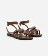 Sandalias planas de cuero color marrón, con múltiples tiras finas ajustables con hebillas doradas. Tira que se ata al tobillo.