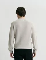 Sweater de punto inglés con escote redondo y mangas largas. Presenta cuello y puños terminados en punto canalé.