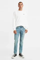 Jean Levi's modelo 512 Slim Taper, de corte ajustado y pierna cónica, en tono azul medio claro con efecto desgastado. Cuenta con cierre de botones y diseño clásico de cinco bolsillos.
