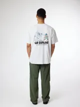 Camiseta gris melange de corte oversize, con estampa en la espalda que incluye un diseño de un Yeti y un excursionista junto con el texto "Go Explore".
