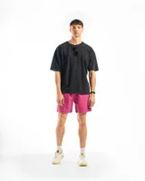 Short de baño de microfibra negro, con cordón blanco ajustable en la cintura, bolsillos laterales y un bolsillo trasero con tapa. Presenta un pequeño parche cuadrado con un logo en la parte inferior del muslo izquierdo.