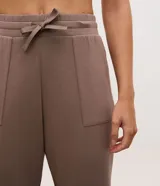 Pantalón tipo jogger de mujer, confeccionado en tejido modal con mezcla de poliéster y elastano. Presenta cintura elástica con lazo de ajuste, bolsillos laterales y puños elásticos en el ruedo.