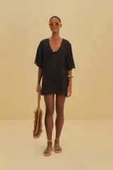 Vestido túnica corto negro de algodón con bordados calados, escote en V y mangas cortas holgadas.