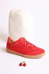 Zapatillas rojas de gamuza con cordones blancos y suela de goma color caramelo.