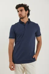 Remera tipo polo de manga corta, color azul marino jaspeado, con cuello y ribetes en las mangas de color azul oscuro y blanco.