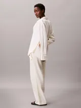 Pantalón cargo de corte relajado confeccionado en una mezcla de lino y algodón. Presenta cintura elástica, bolsillos laterales amplios con solapa y diseño de pierna ancha.