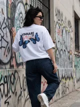 Remera blanca de algodón con cuello redondo y estampado en la espalda con la frase "Vinnare of Butterflies" y dos mariposas azules.
