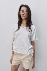 Remera blanca de manga corta con escote en V y silueta amplia. Con costuras visibles en contraste.