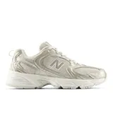 Championes urbanos New Balance modelo 530, color beige con detalles metalizados. Presentan una estructura de malla transpirable con refuerzos de cuero sintético, entresuela con tecnología ABZORB para mayor amortiguación y cierre mediante cordones.