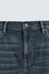 Pantalón de jean corte slim fit, color gris con efecto lavado. Presenta diseño de cinco bolsillos, cierre frontal con cremallera y botón, y tejido elástico.