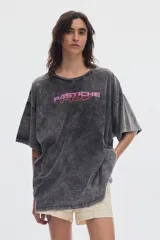 Remera boxy de manga corta y cuello redondo, con efecto de lavado acid wash en tono gris y estampa frontal en tonos rosado y rojo.