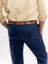 Pantalón chino de corte regular y tiro medio, color azul marino, con cierre de botón y cremallera, bolsillos laterales y traseros, y terminación recta.