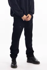 Pantalón de jean azul oscuro de corte recto, con refuerzos en las rodillas y bolsillos laterales. Diseño de estilo cargo con frente reforzado.