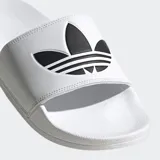 Sandalias Adidas Adilette Lite blancas con logo negro de Adidas en la tira superior.