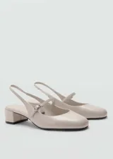 Zapato destalonado color beige con efecto charol, punta redonda, tacón bloque de 5 cm y cierre de tira con hebilla.