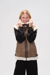 Chaleco negro de efecto cuero con forro y cuello de corderito. Presenta cierre frontal de cremallera, bolsillos laterales y diseño sin mangas.