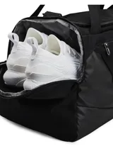 Bolso deportivo Under Armour Undeniable 5.0 Medium, color negro con el logo de la marca en blanco. Cuenta con tecnología UA Storm resistente al agua, compartimento principal con cierre, bolsillo ventilado para ropa sucia o calzado, bolsillos laterales para botellas y correa de hombro ajustable y acolchada.