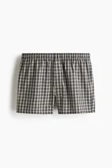 Pack de dos calzoncillos tipo boxer de tela suave, con cintura elástica y bragueta de botones. Ambos presentan diseños a cuadros en tonos blanco y negro.
