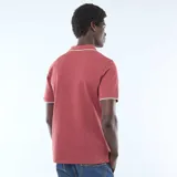 Remera polo de piqué de algodón color rojo, con cuello y puños acanalados en contraste blanco, y cierre frontal de tres botones.