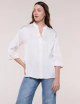 Camisa de satén azul marino con cuello mao, escote en V y mangas tres cuartos con hombro caído. Presenta silueta holgada, cierre frontal con botones y ruedo asimétrico.