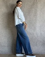 Pantalón de jean estilo wide leg con costuras verticales frontales, tiro alto y bolsillos laterales.