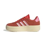 Championes Adidas modelo VL Court Bold con diseño de plataforma elevada. Presentan una capellada de gamuza en tono rojizo, con las icónicas tres tiras laterales en combinación de blanco y rosado. Incluyen suela de caucho en color crema y detalle de logo en el talón.
