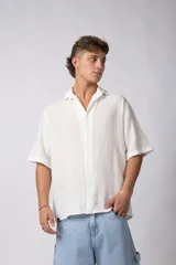 Camisa de manga corta confeccionada en lino, con cuello clásico y cierre frontal de botones. Presenta un corte relajado y textura liviana.