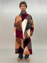 Tapado oversize desestructurado de lana merino afieltrada, ensamblada y teñida en degradé. Con bolsillos laterales, puños amplios y cierre con broches ocultos. Más largo en la parte inferior trasera.