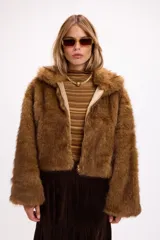 Campera corta de pelo sintético en color marrón, con diseño de volumen protagonista, cuello alto y cierre frontal.