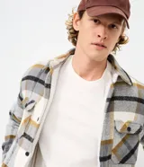 Campera de franela a cuadros con forro interno de sherpa, cierre frontal con botones, cuello camisero y bolsillos frontales en el pecho.