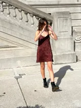 Vestido corto dorado de tejido de punto con breteles finos y escote en V.