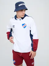 Canguro deportivo Umbro del Club Nacional de Football, modelo Evoque. Diseño con bloques de color blanco en el torso, azul en la capucha, laterales y parte superior de las mangas, y rojo en los puños. Incluye capucha con cordón ajustable, logo de Umbro y escudo del club bordados en el pecho.