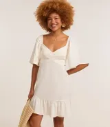 Vestido corto evasê de viscolino color crudo, con escote en V, mangas cortas amplias, recorte cut-out en los laterales de la cintura y volado en el ruedo.