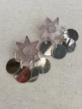 Aros dorados con forma de flor brillante en la parte superior y múltiples discos metálicos colgantes.