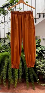Pantalón tipo babucha color camel, con cintura y puños elastizados, bolsillos delanteros y confeccionado en 100% algodón.