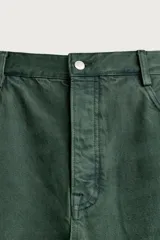 Jeans relaxed fit de algodón color verde oscuro, de tiro medio y pernera recta con raya de planchado. Cuenta con diseño de cinco bolsillos y cierre frontal con cremallera y botón.
