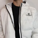 Campera inflada negra con capucha, cierre frontal blanco y puños elásticos acanalados. Presenta el logo de la marca Santa Barbara Outfitters bordado en el pecho.