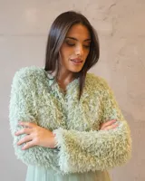 Chaqueta cropped de textura peluda en color verde agua, con diseño de manga larga y acabado suave. Ideal para complementar outfits de ocasión.
