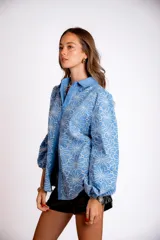 Camisa color crema con bordado de flores blancas, de manga larga abullonada y cuello clásico.